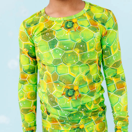 Long-sleeve shirt with green and yellow geometric pattern on a light blue background.