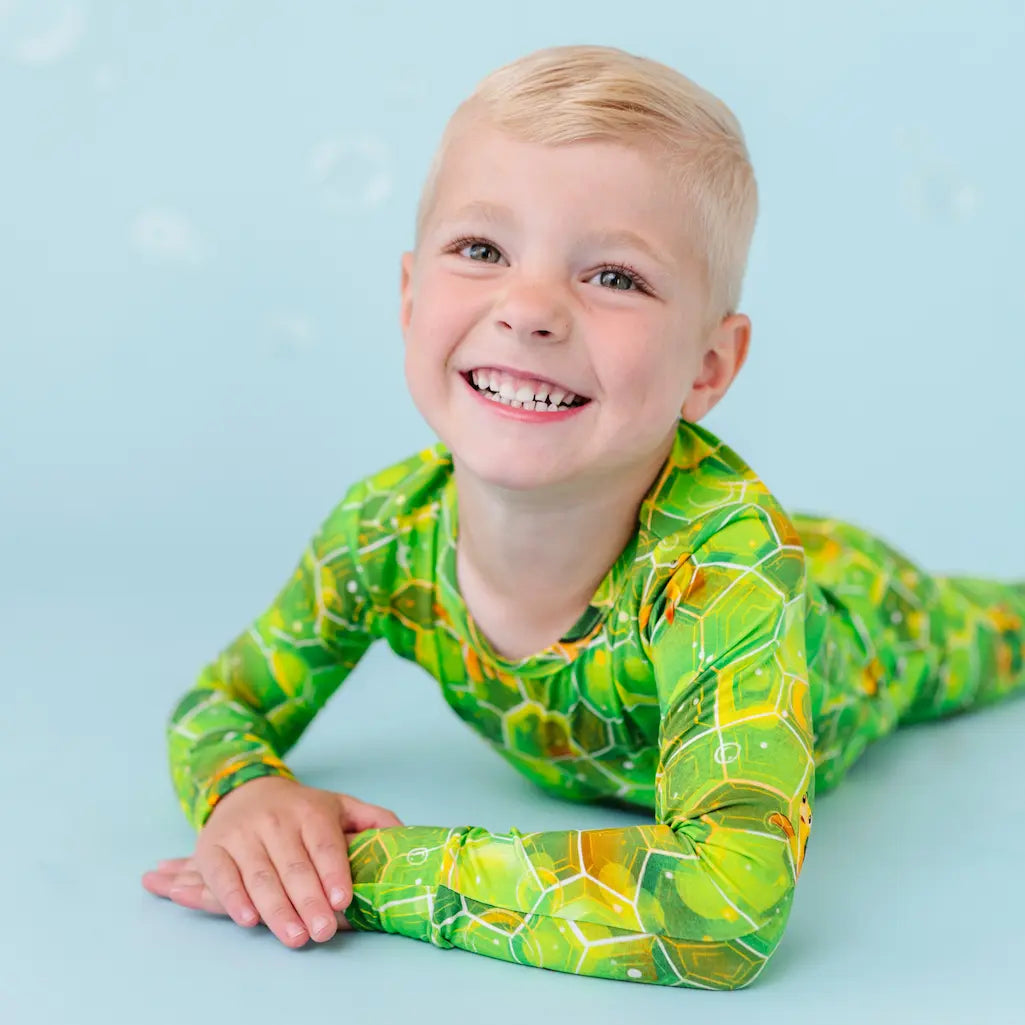 Child wearing a green marble patterned outfit on a blue background