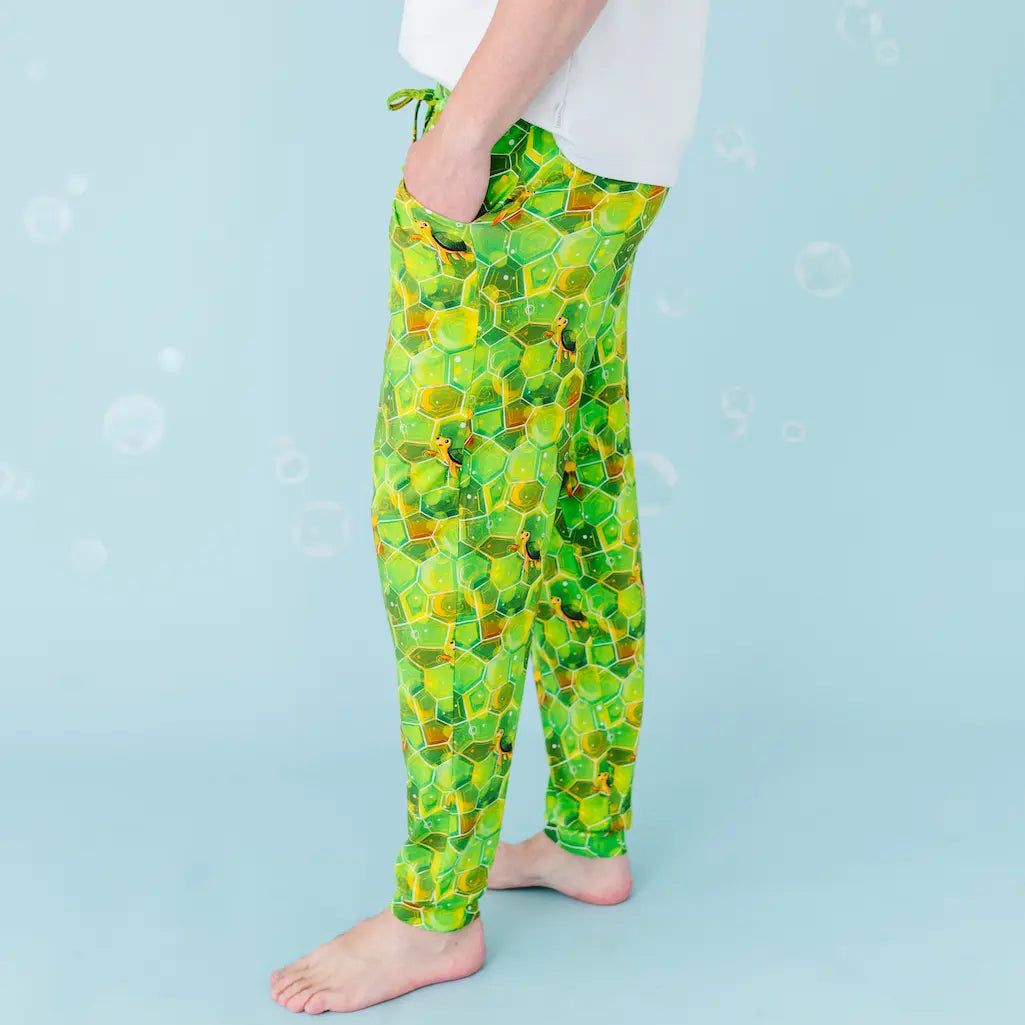 Person wearing green patterned pants on a light blue background
