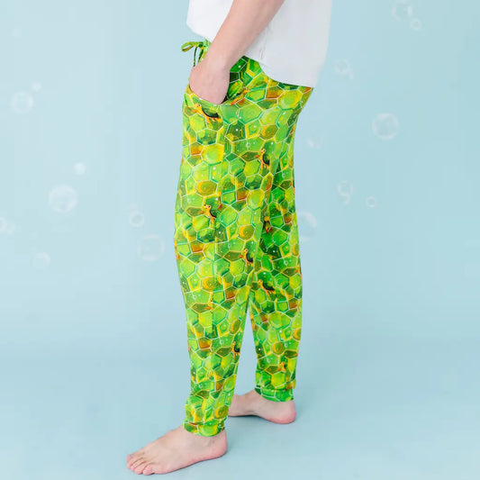 Person wearing green patterned pants on a light blue background
