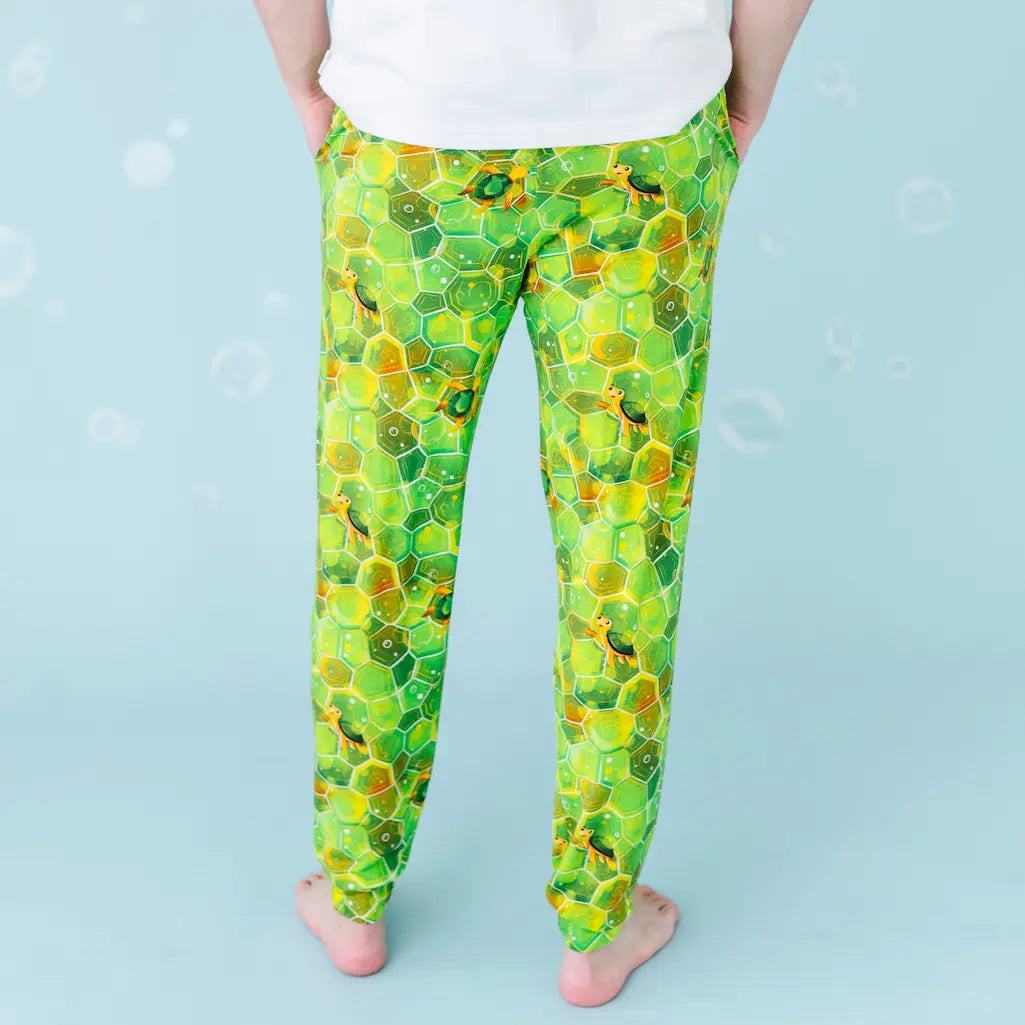 Green and yellow patterned leggings worn by a person on a light blue background.