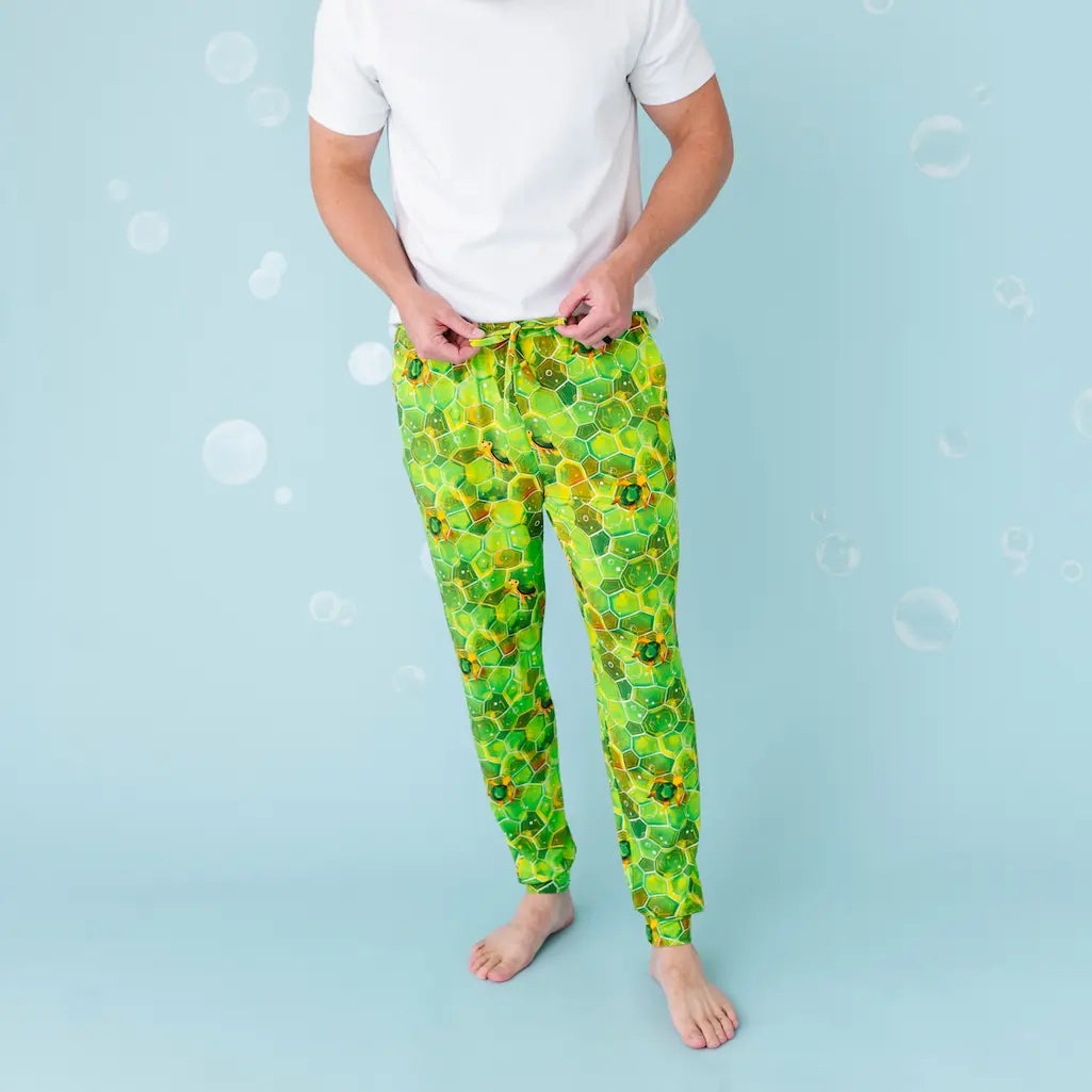 Person wearing green floral pajama pants on a light blue background