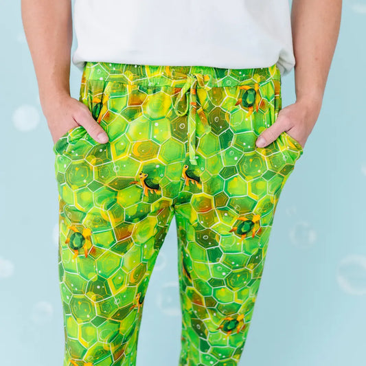 Green honeycomb patterned pants worn by a person against a light blue background.