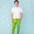 A man wearing white t-shirt and green pajama pants with a geometric sea turtle pattern.