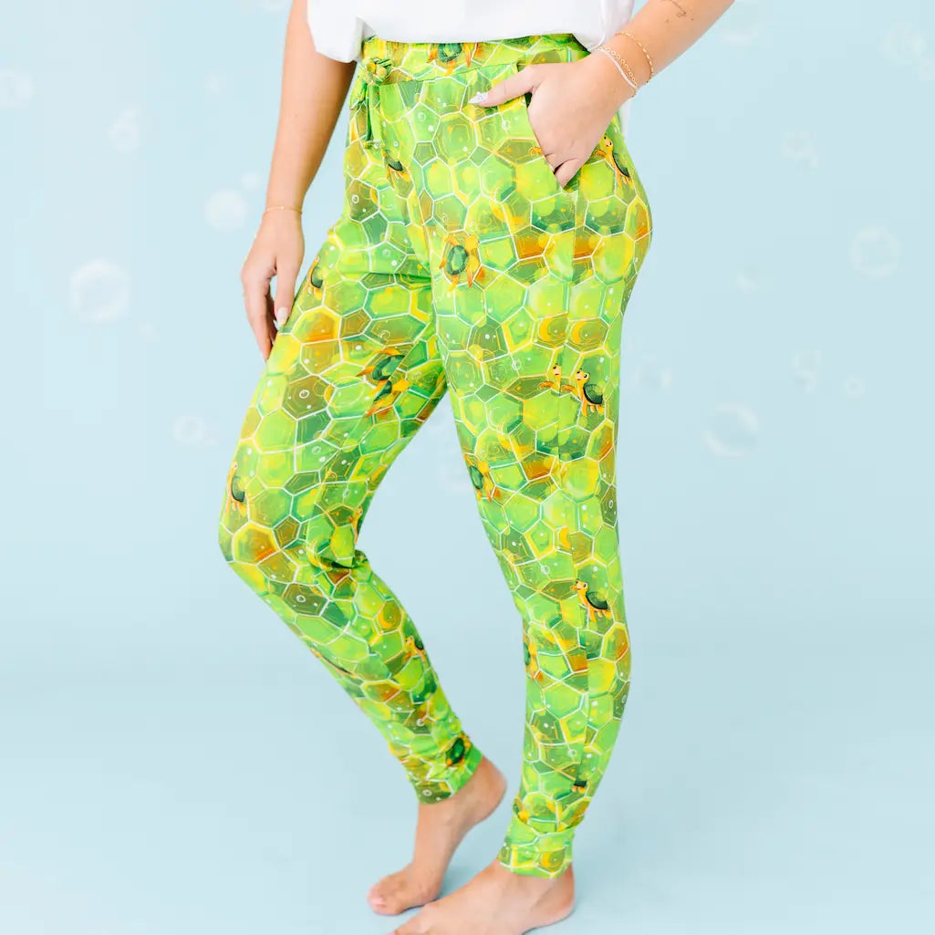 Person wearing green and yellow patterned leggings on a light blue background.
