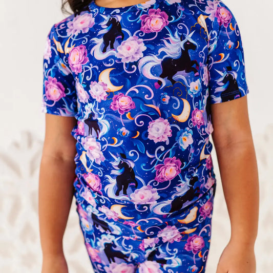 Person wearing a blue shirt with unicorn and floral pattern