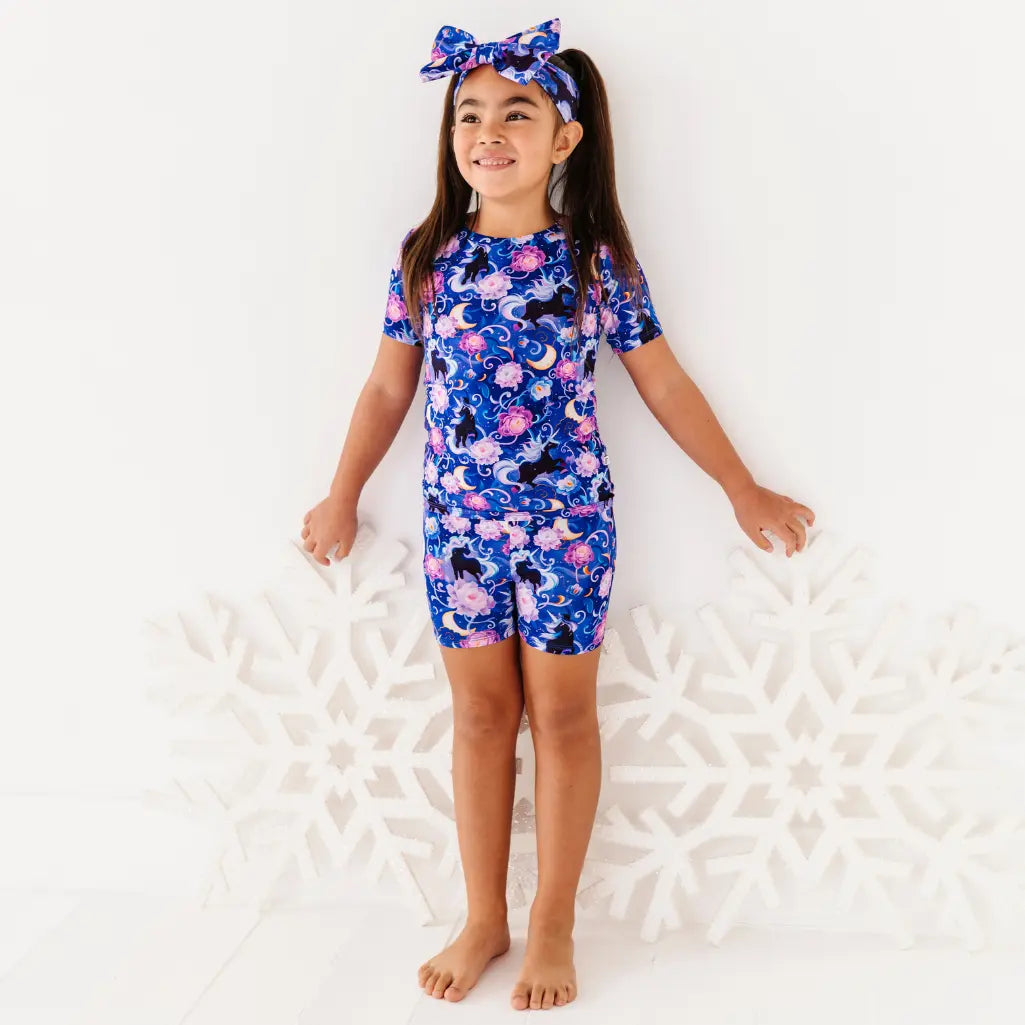 Young girl wearing a blue floral swimsuit on a white background