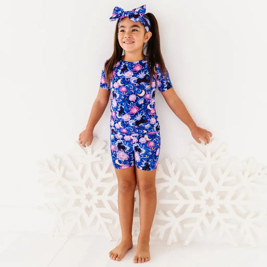Young girl wearing a blue floral swimsuit on a white background