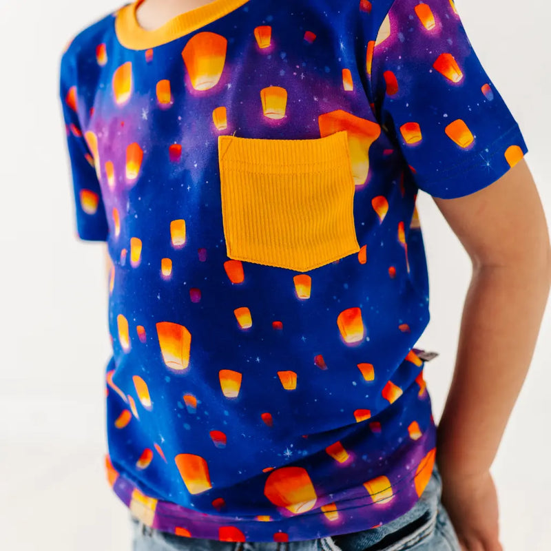 Person wearing a colorful t-shirt with candy corn pattern on a white background
