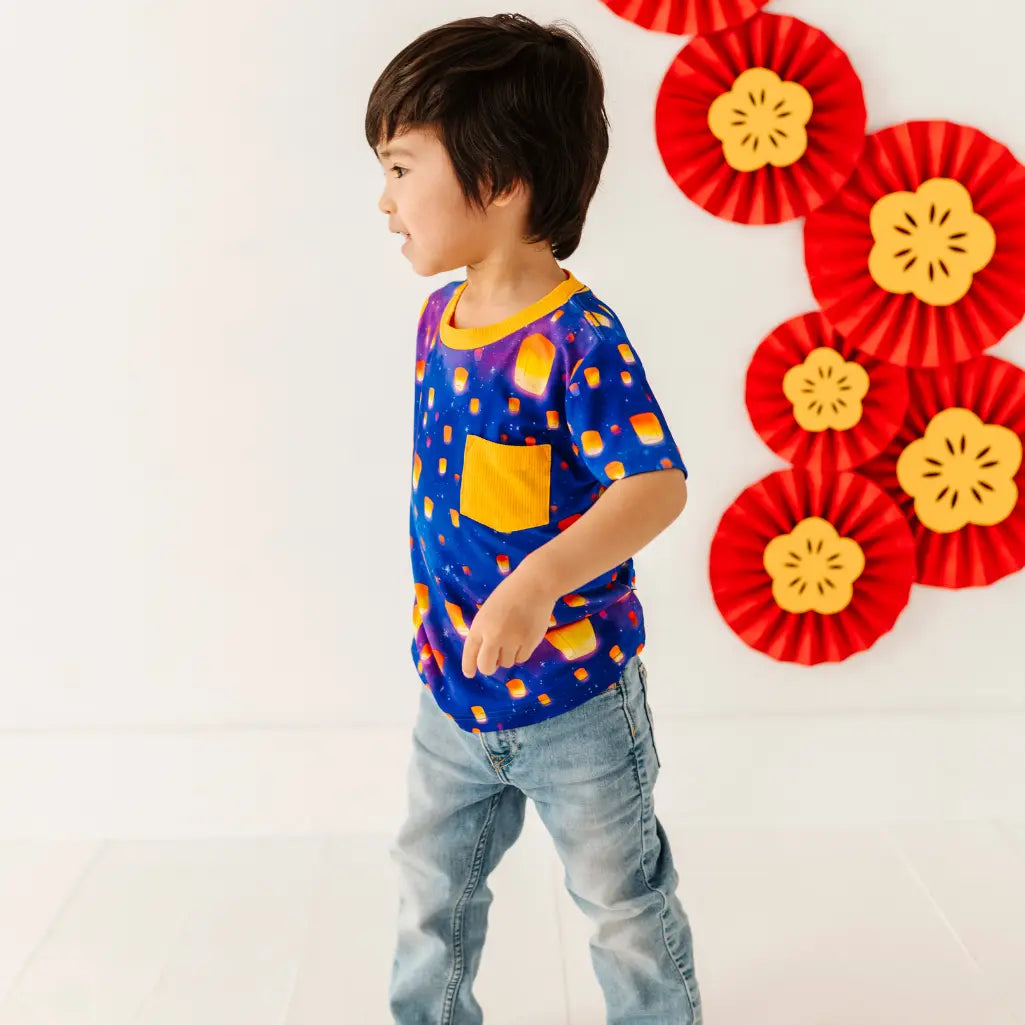 Child wearing a colorful shirt with a red and yellow floral backdrop