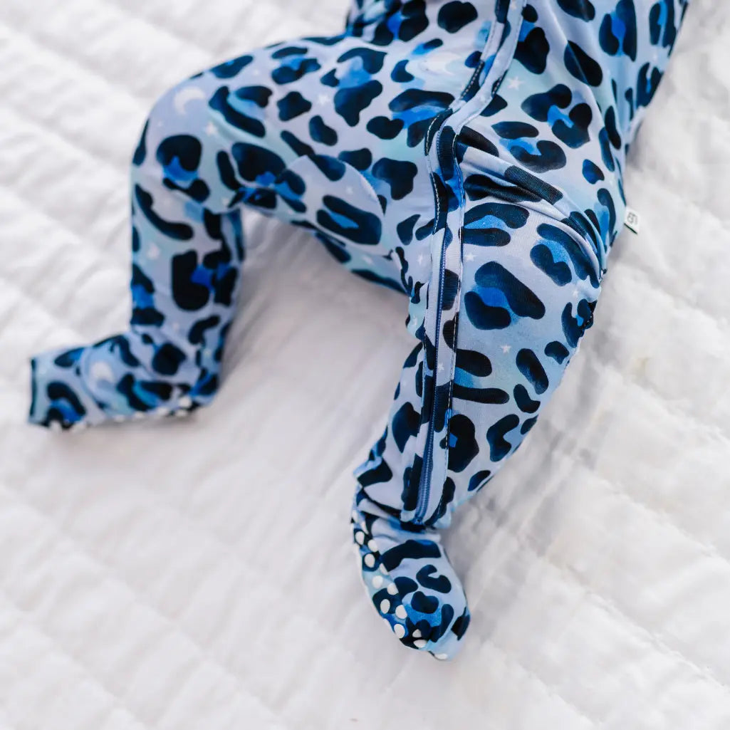 Blue leopard print baby romper on a white textured surface