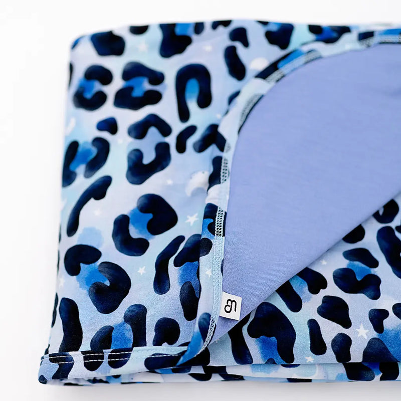 Folded fabric with blue and black leopard print pattern on a white background
