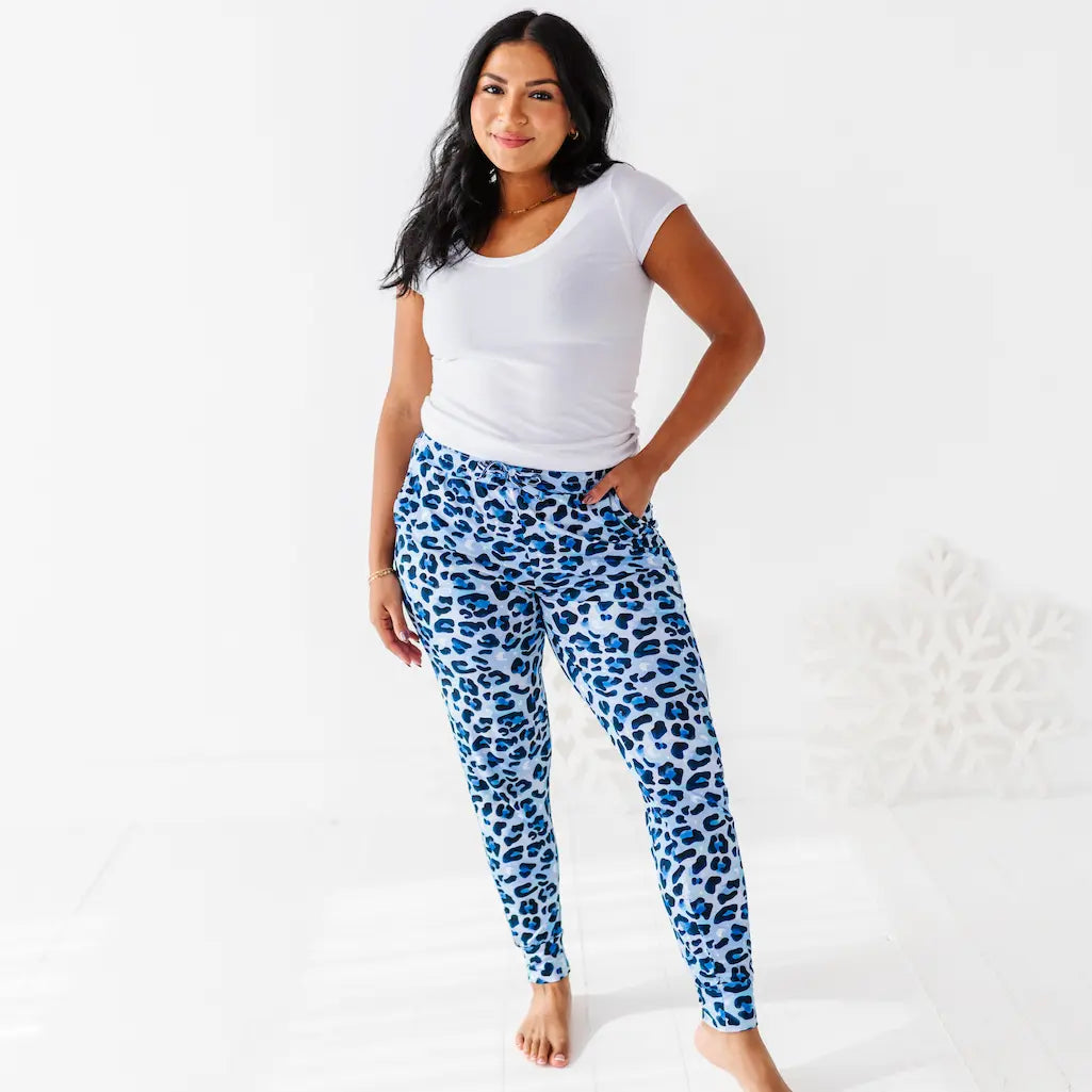 Woman wearing blue leopard print leggings and a white t-shirt on a white background