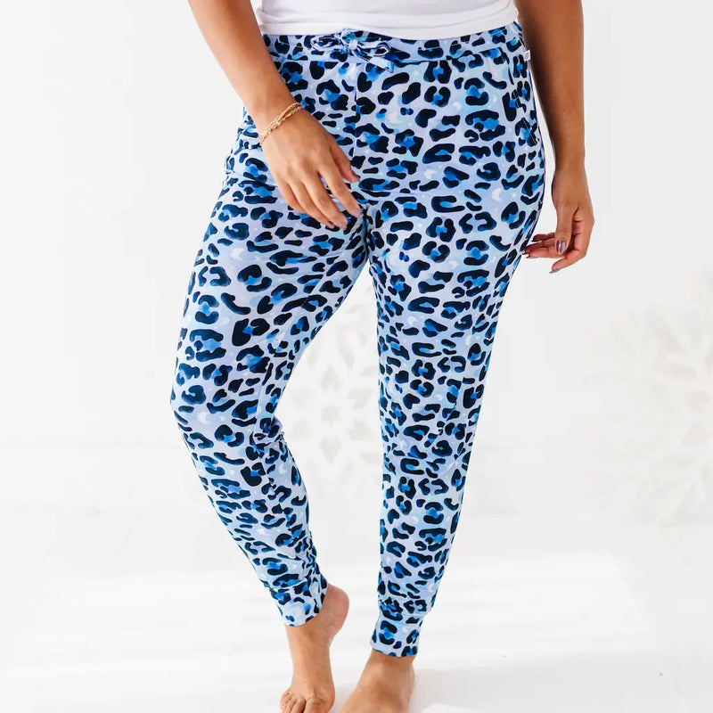 Blue leopard print pants worn by a person on a white background