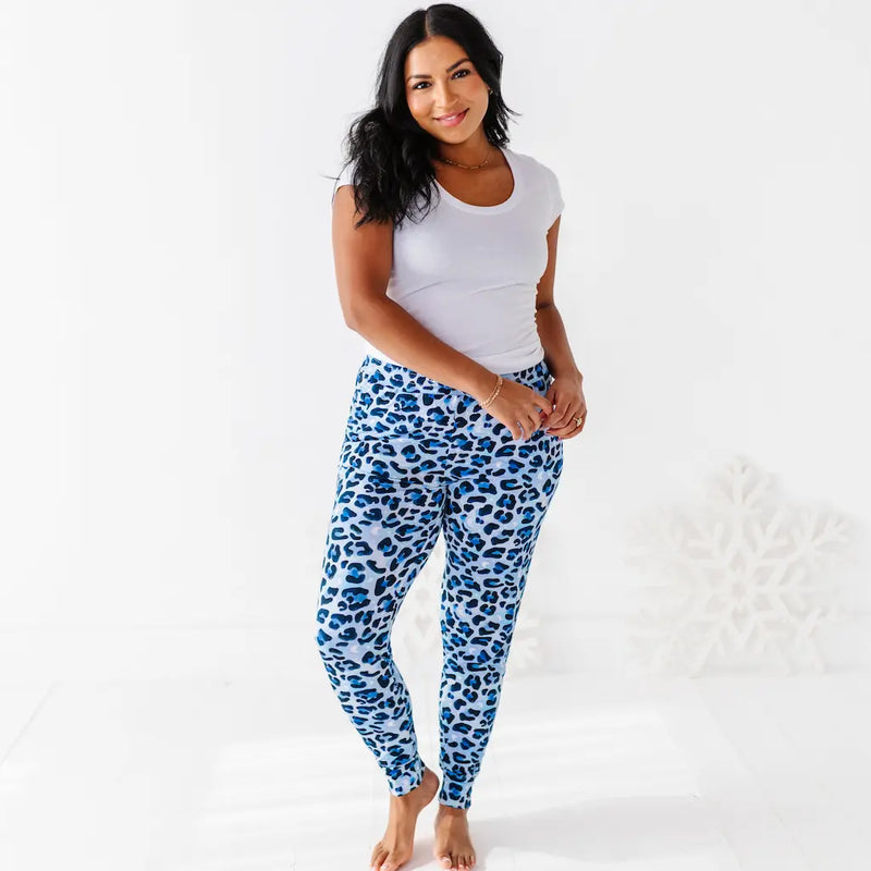 Woman wearing blue leopard print pants and a white top on a white background