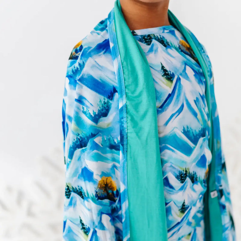 Scarf with mountain and tree pattern over a white background