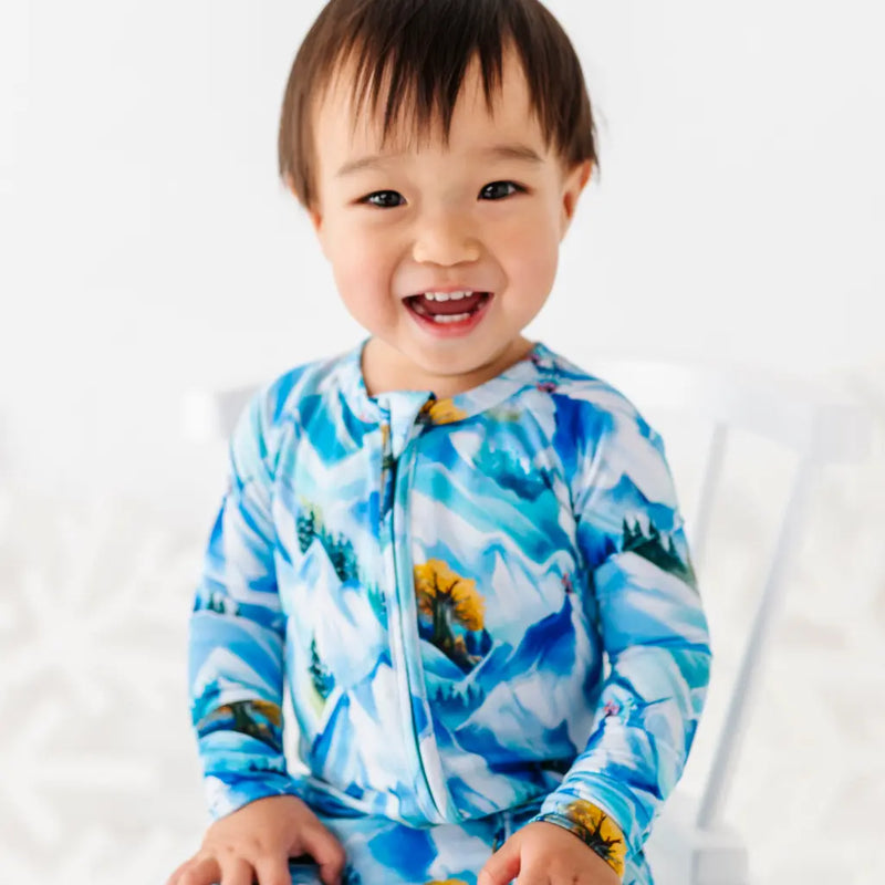 Child wearing a blue and white patterned outfit with a white background