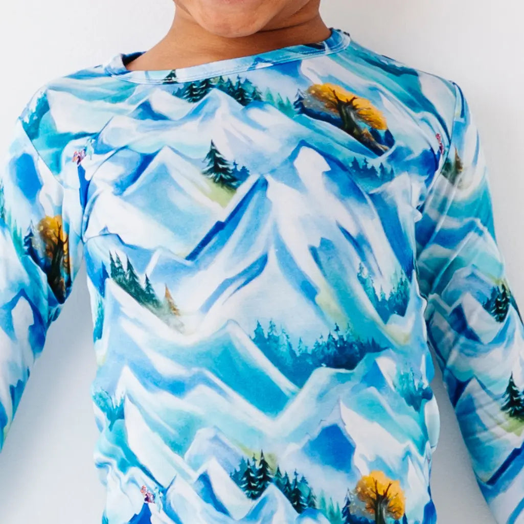 Children's long-sleeve shirt with a mountain and forest design on a white background
