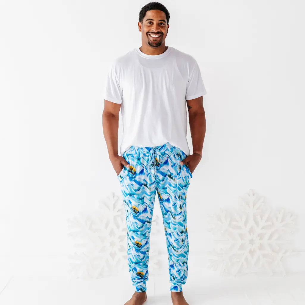 Man wearing a white t-shirt and blue patterned pants on a white background