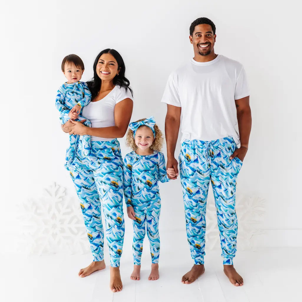 Child wearing an orange and yellow swimsuit with a matching headband on a light blue background