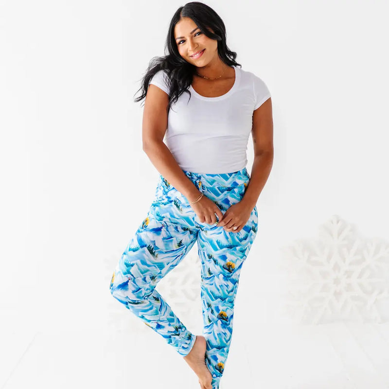 Woman wearing a white top and blue patterned pants on a white background