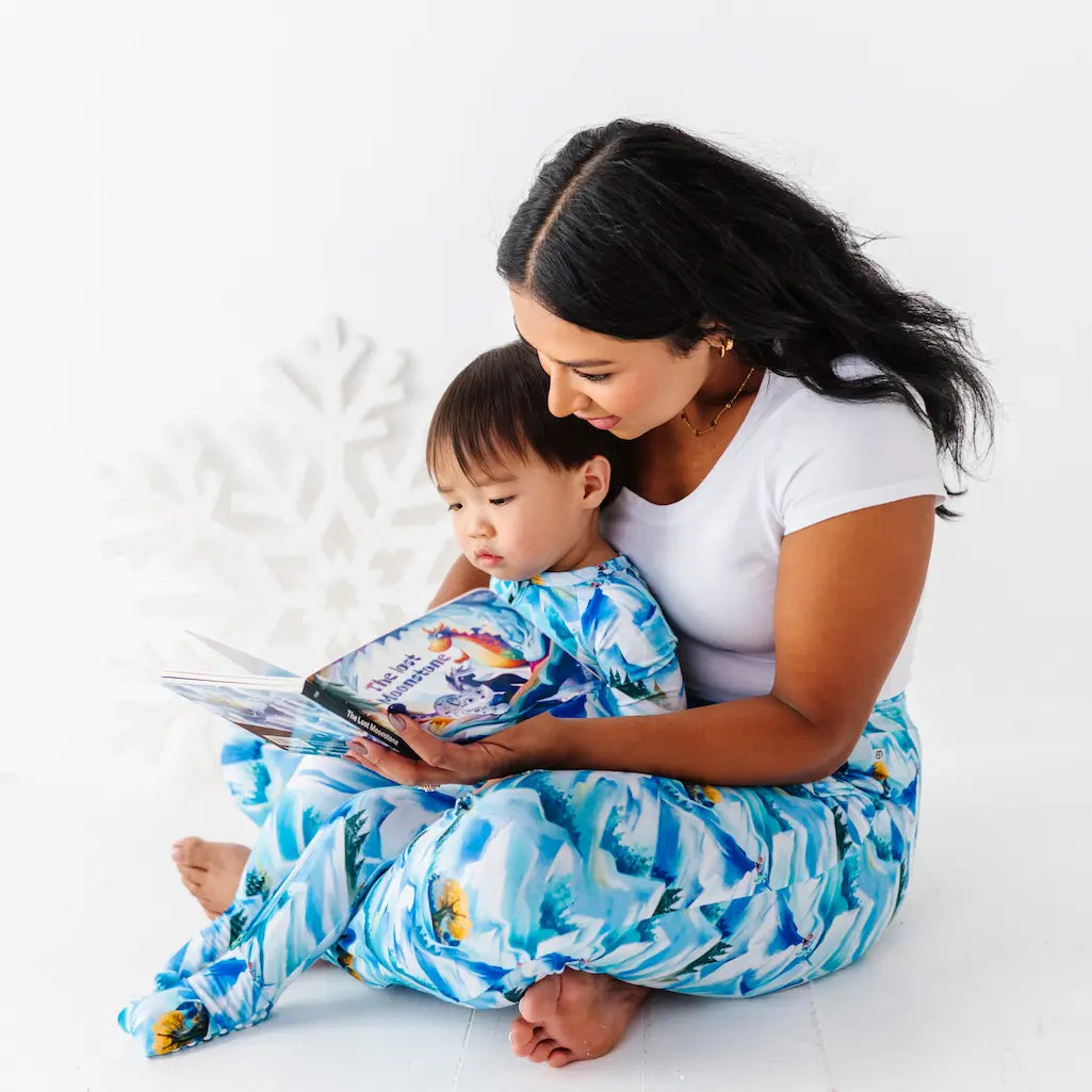 Woman and child reading a book together on a white background