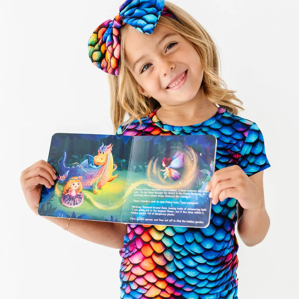 Child in colorful outfit holding a colorful book