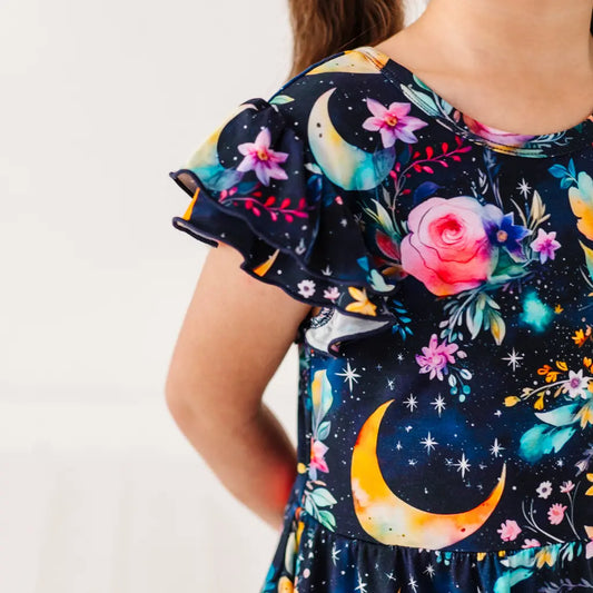 Dress with colorful floral and moon designs on a plain background