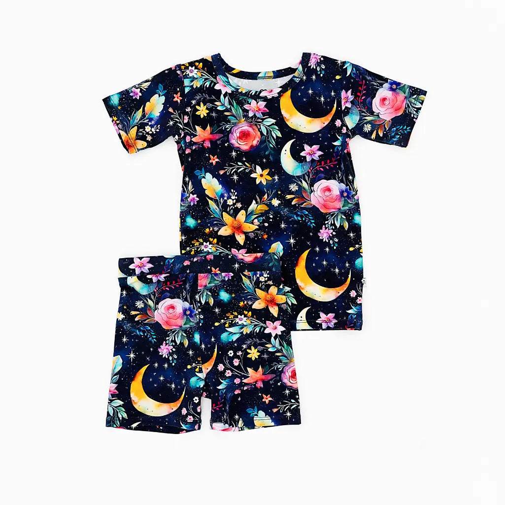 Children's pajama set with celestial and floral pattern on a white background