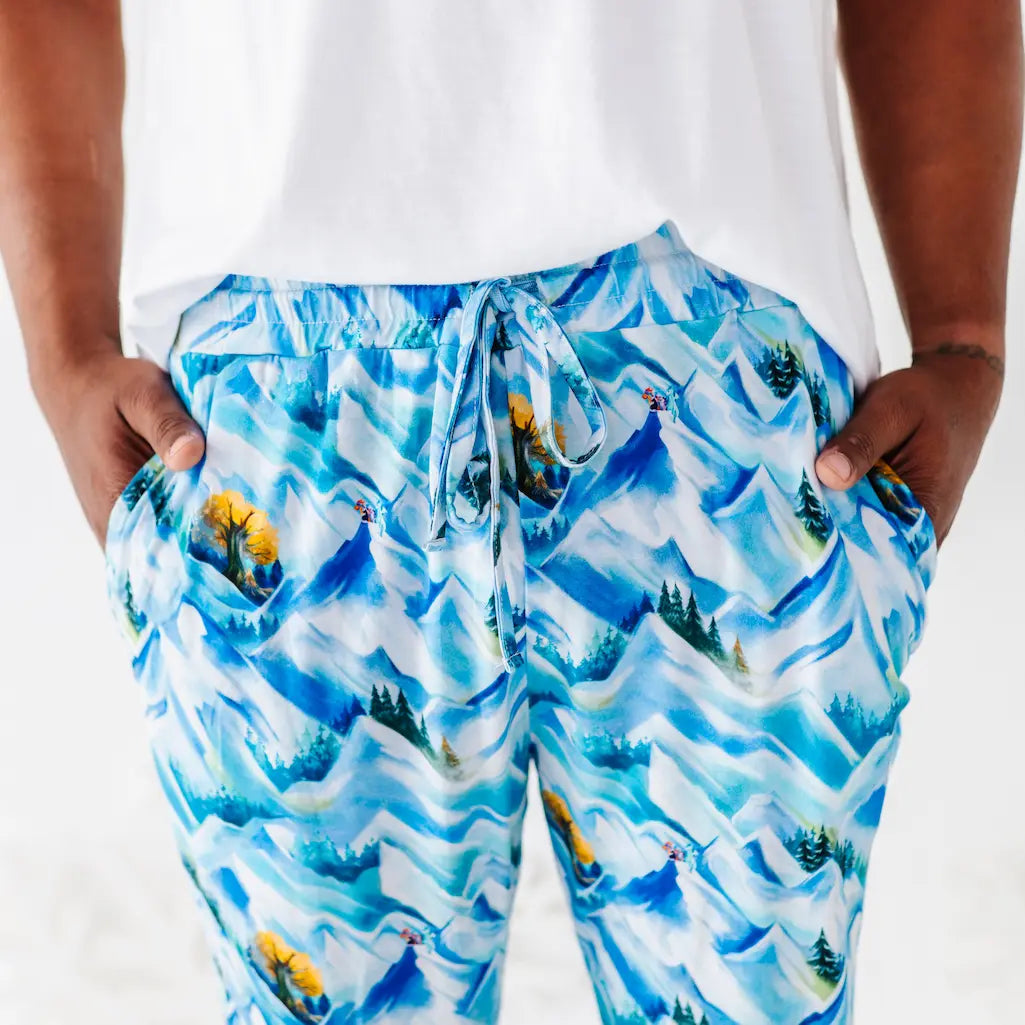 Person wearing blue mountain-patterned shorts on a white background