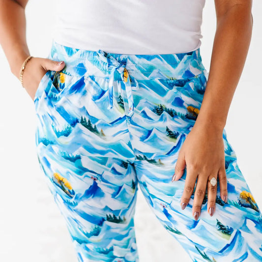 Person wearing blue mountain-patterned pants on a white background