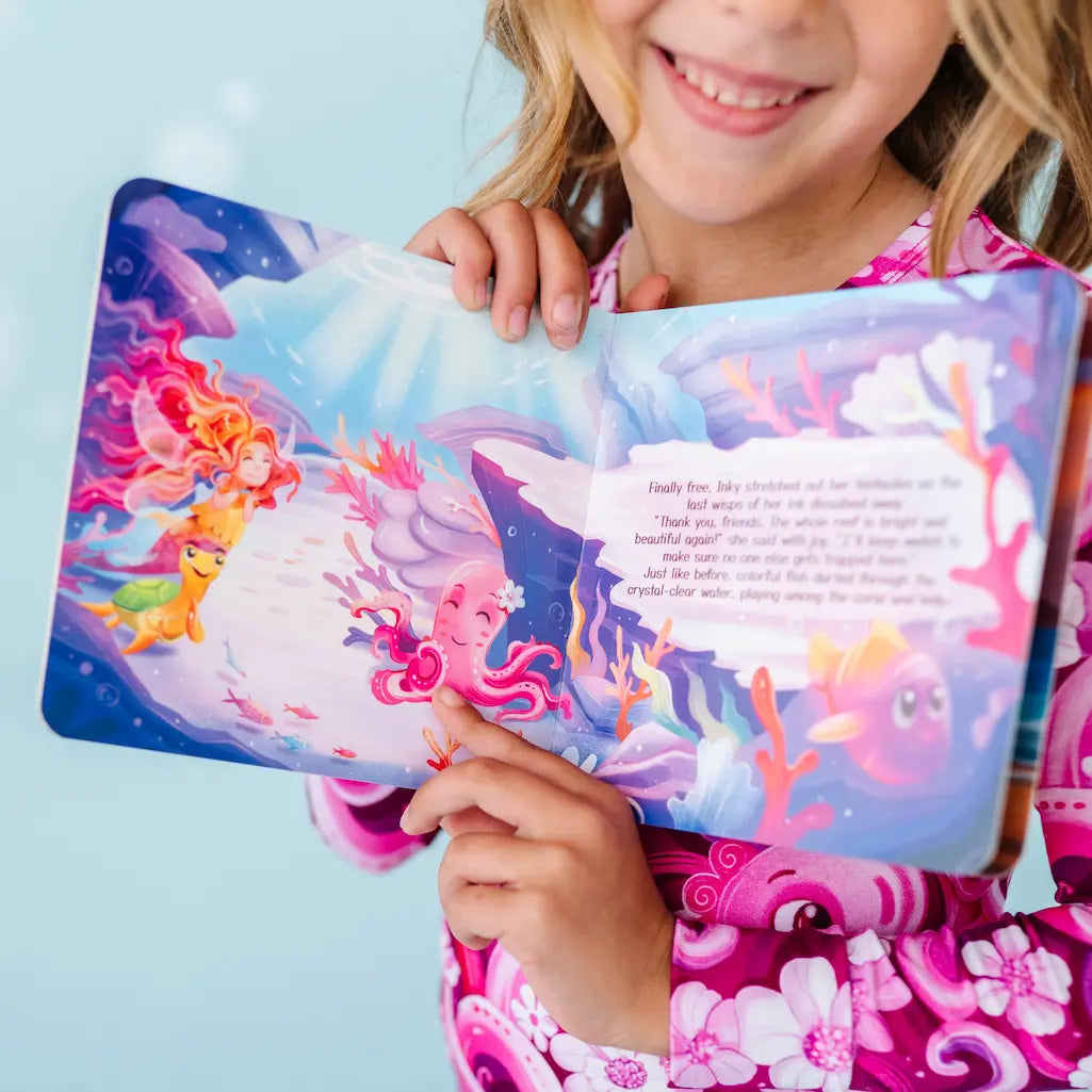 Child holding a colorful underwater-themed book.