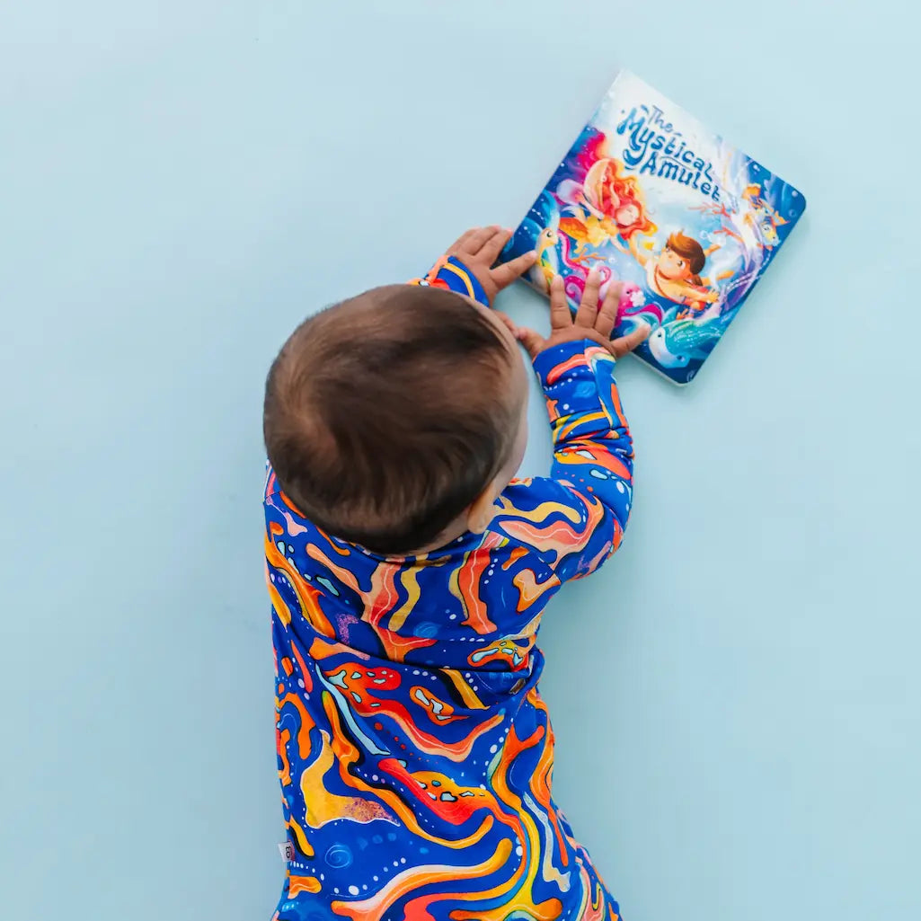 Child in colorful outfit reaching for a book on a light blue wall