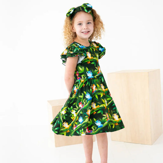 Young girl wearing a green dress with animal print on a white background