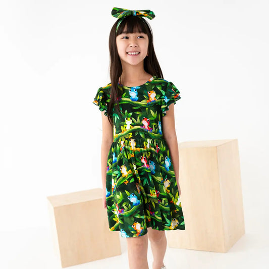 Young girl wearing a green dress with animal prints on a white background