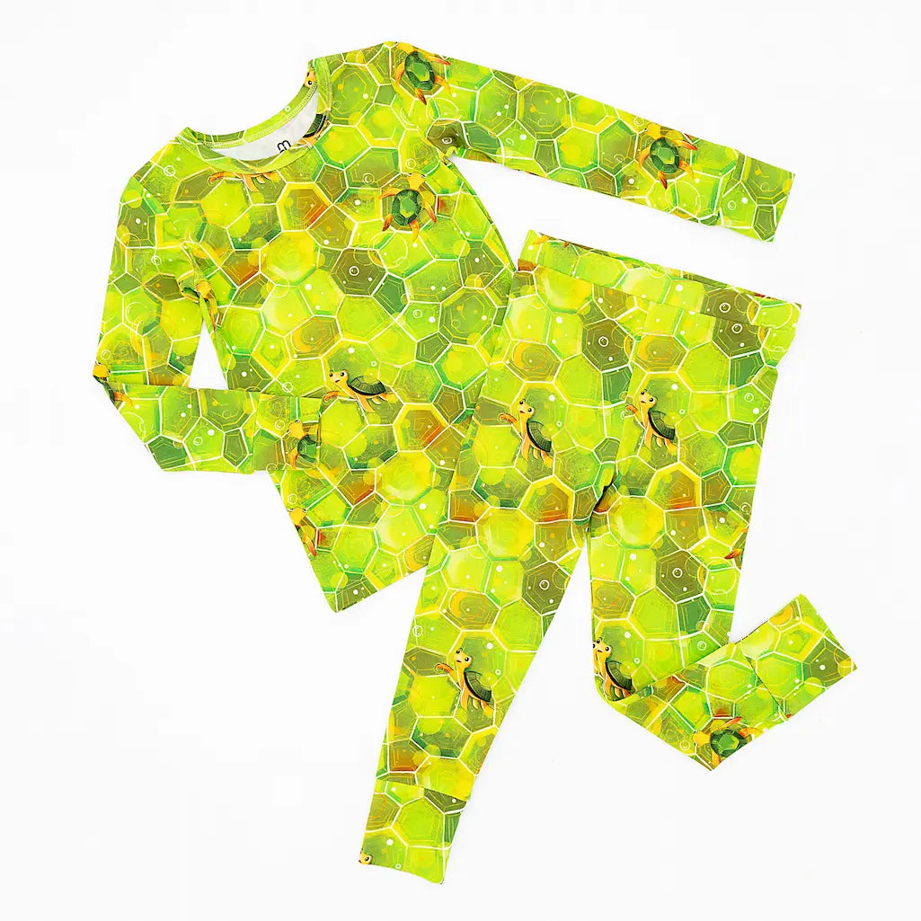 A set of green pajamas with geometric shell patterns, designed for toddlers and kids.