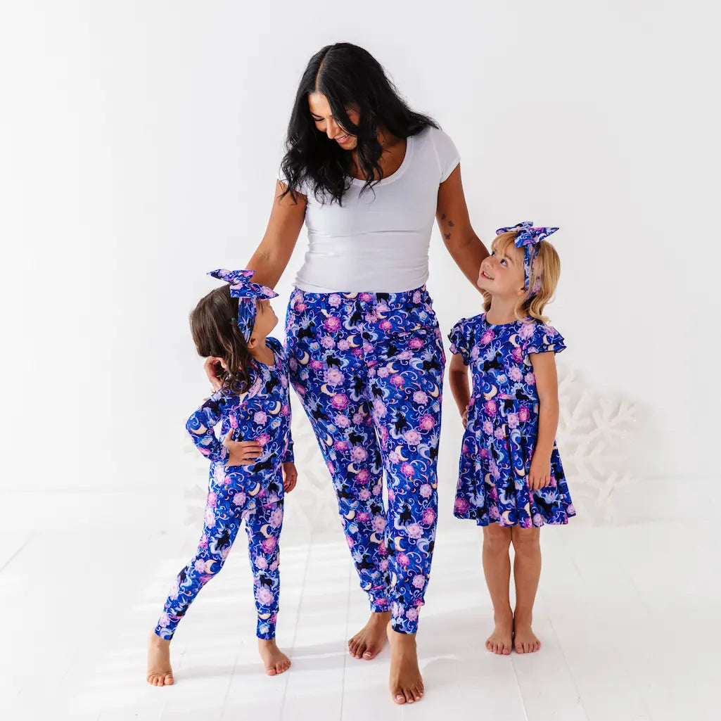 Woman and two children wearing matching floral outfits on a white background