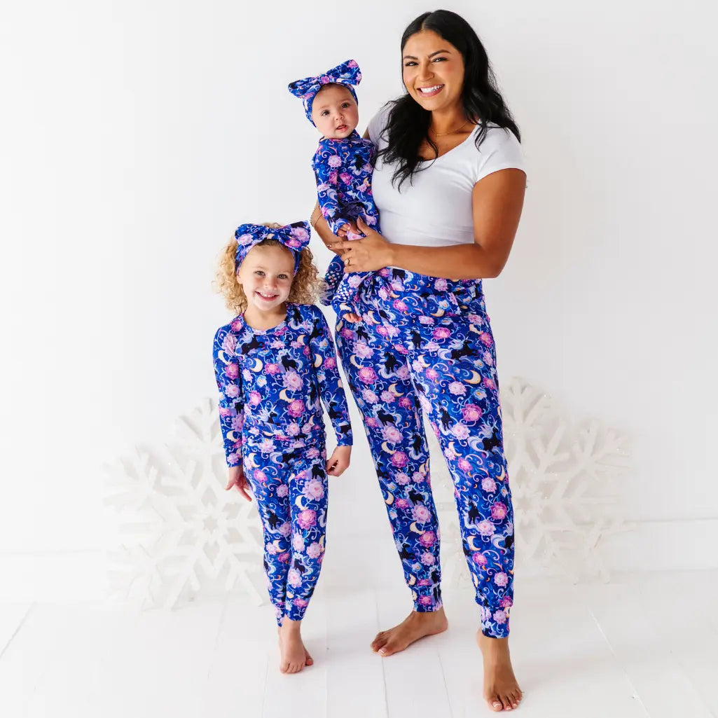 Woman and two children wearing matching blue floral pajamas on a white background