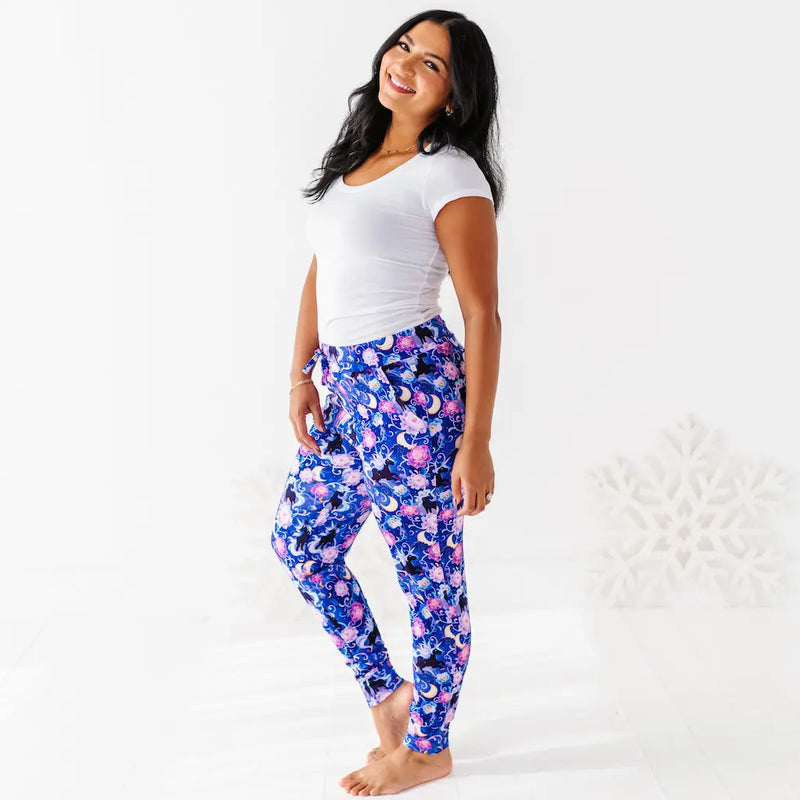 Woman wearing a white top and blue floral leggings on a white background