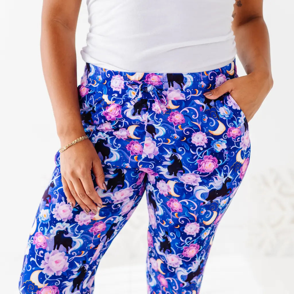 Person wearing blue leggings with black cat and floral pattern on a white background
