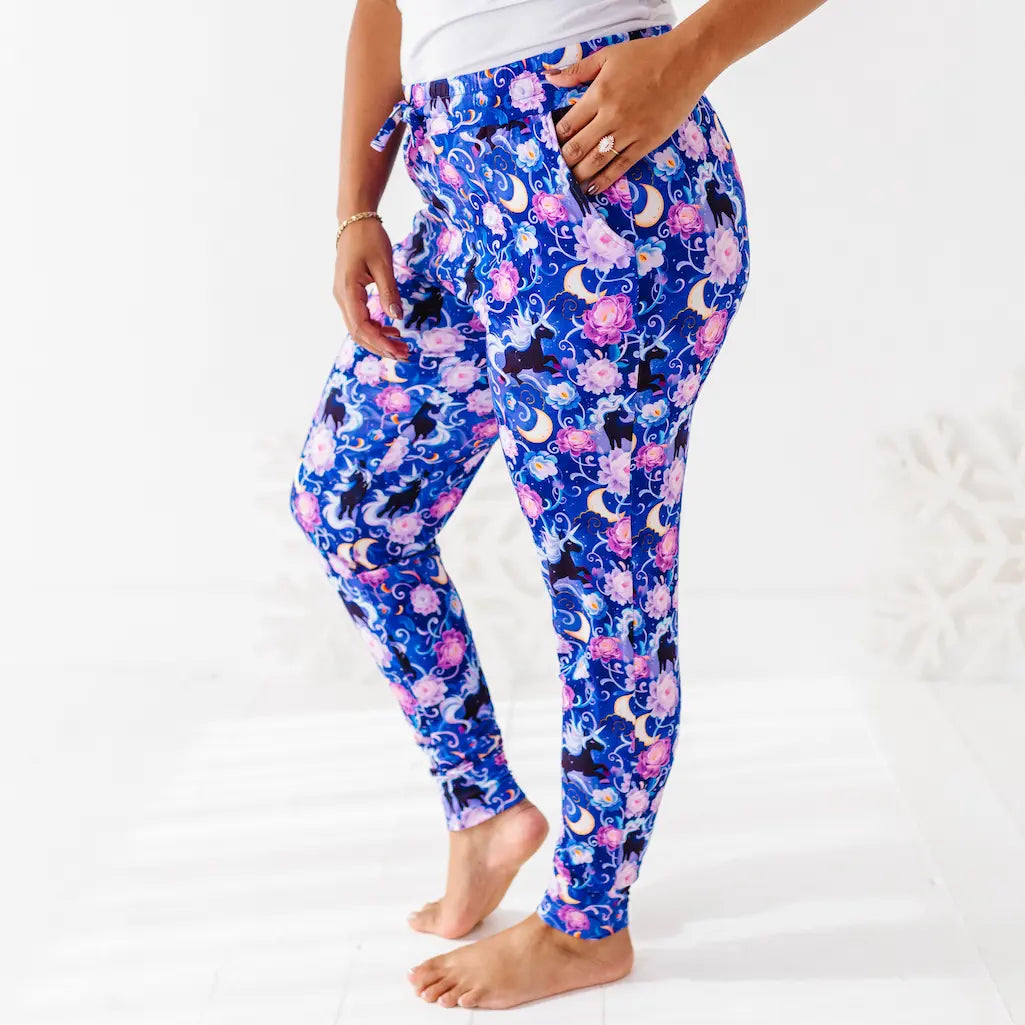 Blue floral and cat print pants worn by a person on a white background