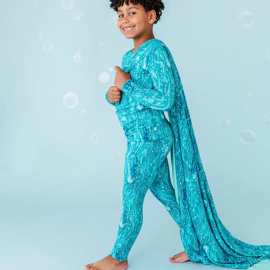 Child in blue sequined outfit on a light blue background