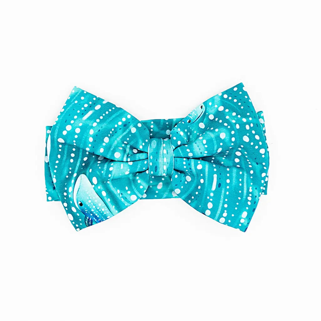 A bow headband with a pattern inspired by a whale shark in teal color.