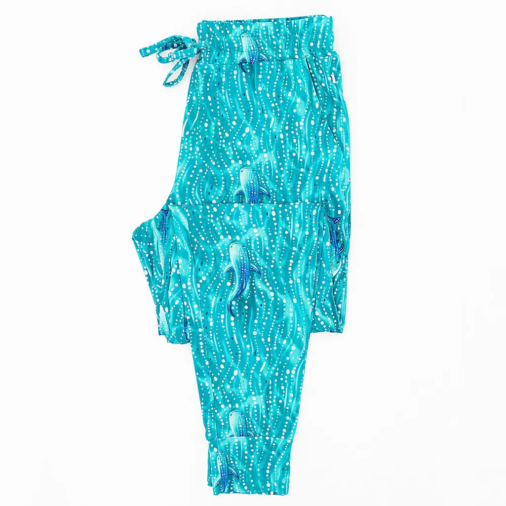 A pair of men's pajama pants with a blue and white wave pattern, featuring an elastic waistband and functional pockets.