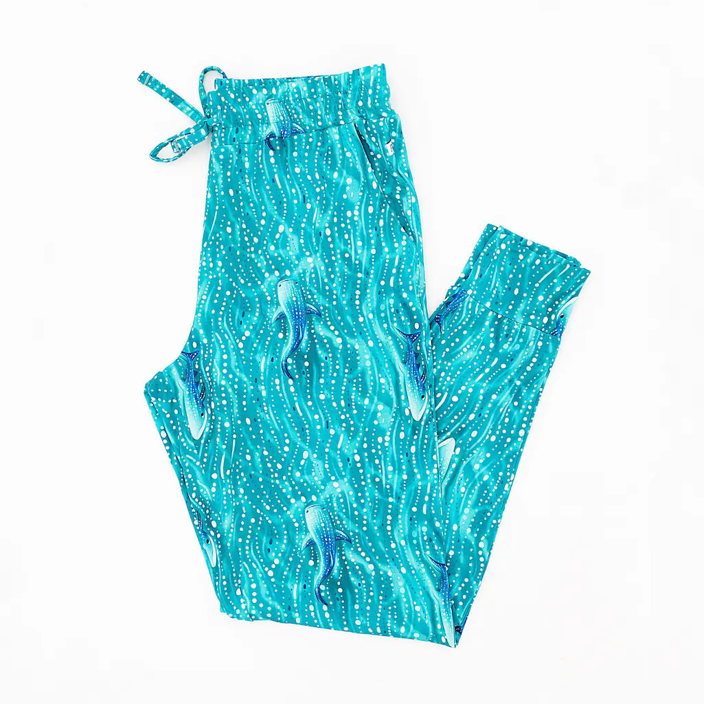 A pair of women's pajama pants with a blue whale shark and underwater pattern, featuring functional pockets and an elastic waistband.