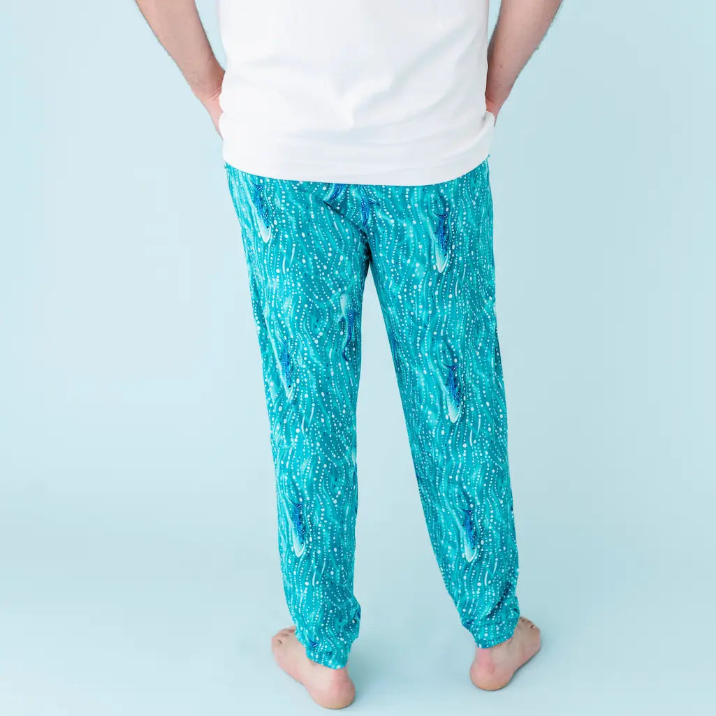 Person wearing teal patterned pants on a light blue background