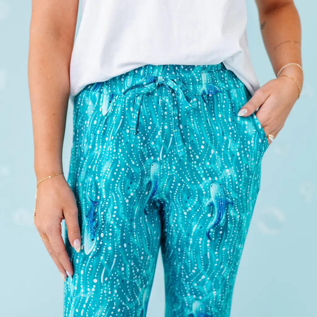 Person wearing blue sequin pants with a plain background.