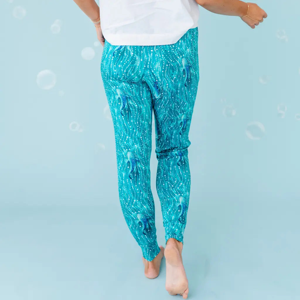 Person wearing teal sequin pants on a light blue background.