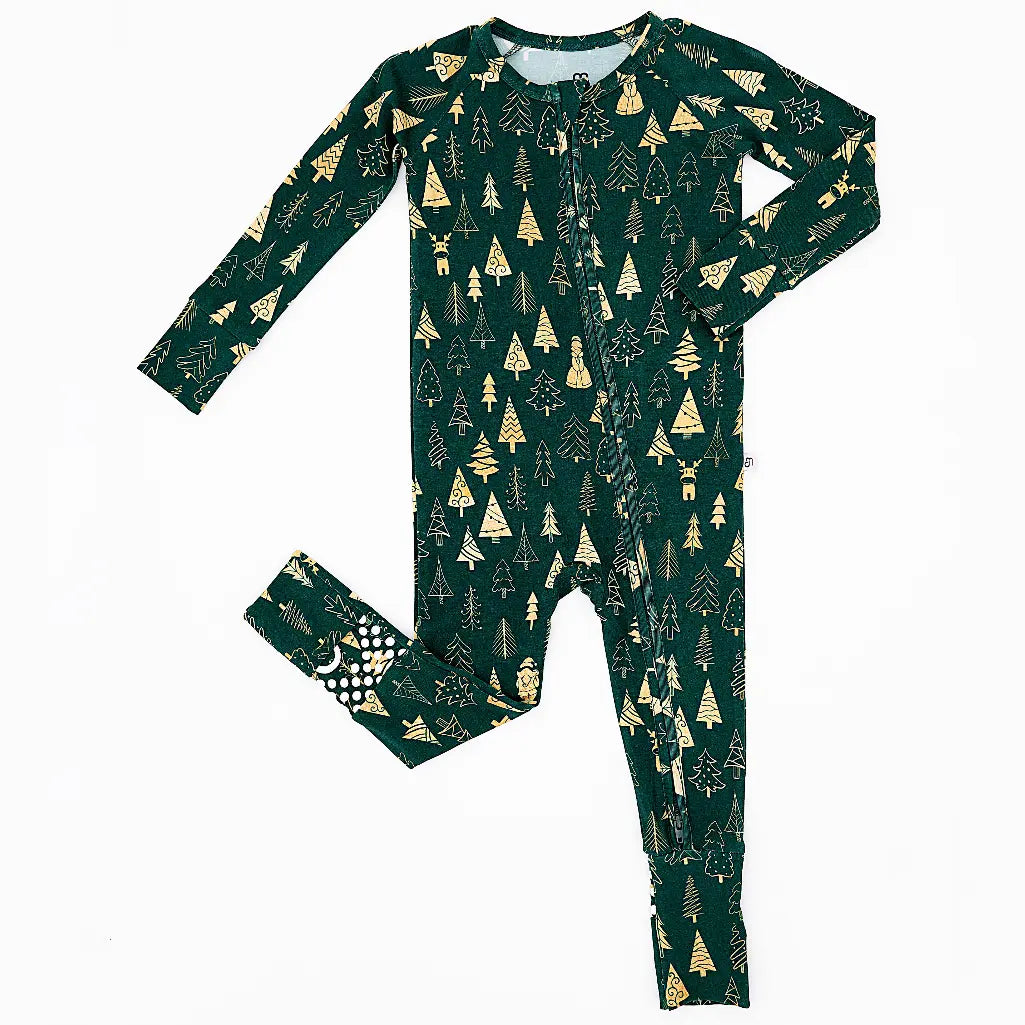 Flat lay of a zip up convertible baby pajama in a dark green print of gold Christmas trees on a white background.