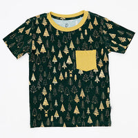 Flat lay of a short sleeve pocket tee with a mustard ribbed collar and pocket in a dark green print of gold Christmas trees on a white background.